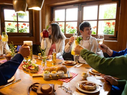 Gäste stoßen mit gehobenen Gläsern beim Frühstück an