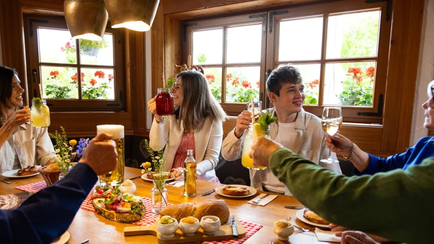 Gäste stoßen mit gehobenen Gläsern beim Frühstück an
