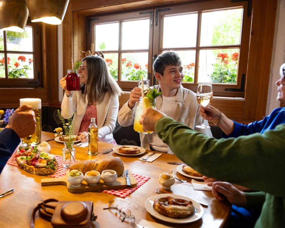 Gäste stoßen mit gehobenen Gläsern beim Frühstück an