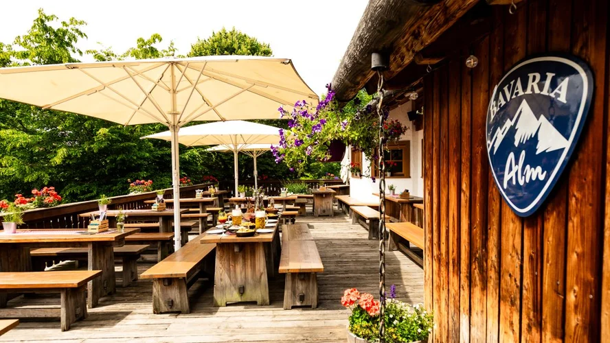 Terrasse einer Bavaria Alm mit Logo