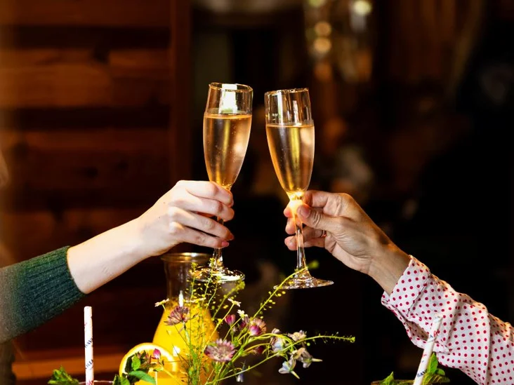 Frühstücks- und Brunch Tisch in einer Bavaria Alm mit zwei angestoßenen Sektgläsern